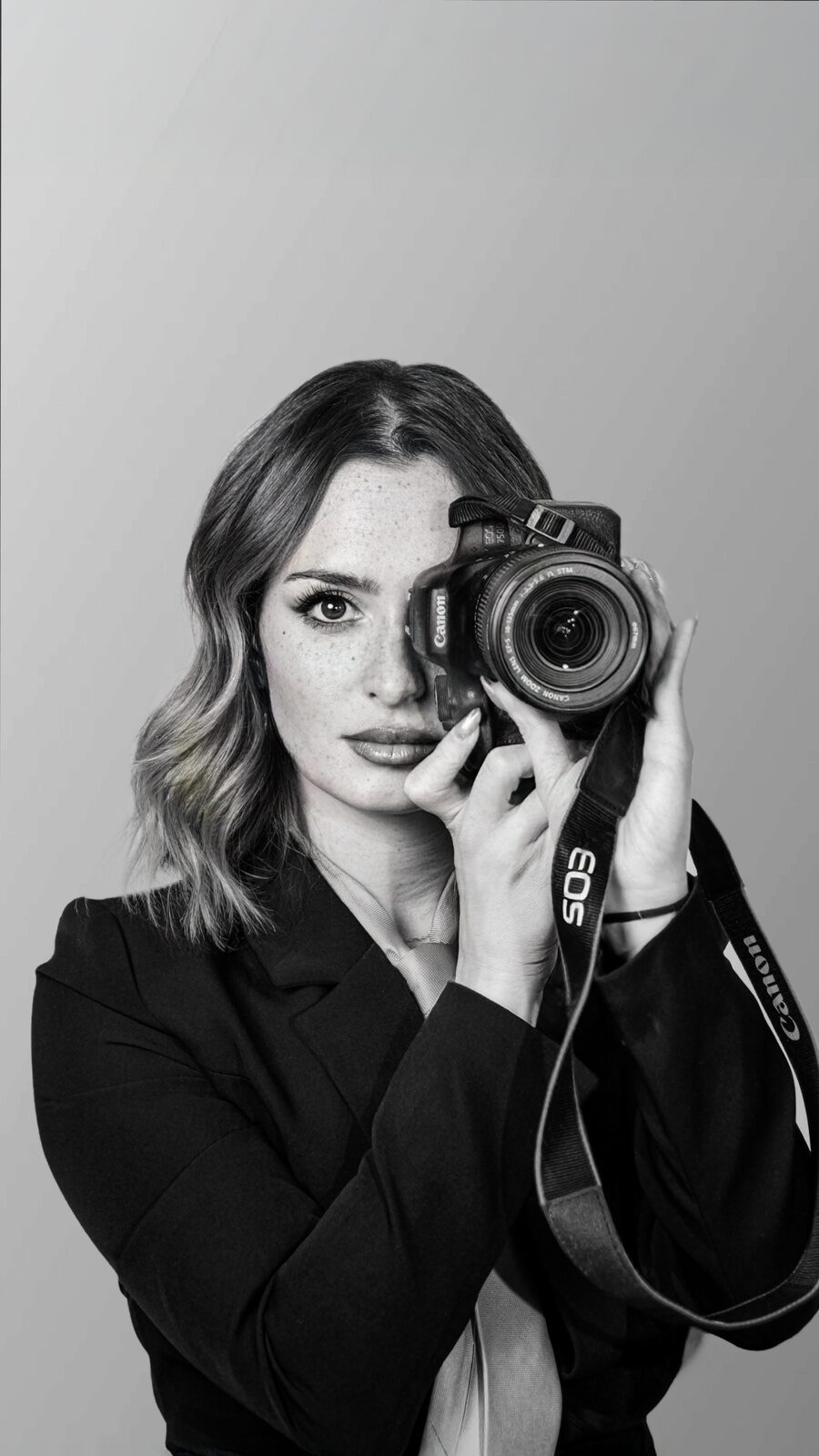 Ritratto in bianco e nero di Elisa Cagnoni con una macchina fotografica